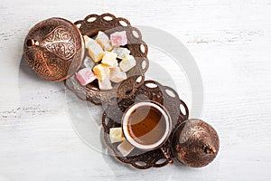 Traditional turkish coffee and turkish delight on white shabby wooden background. Top view