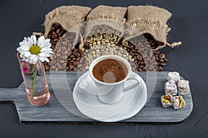 Traditional turkish coffee drink concept. Turkish coffee with glass of water and turkish delights on wooden table