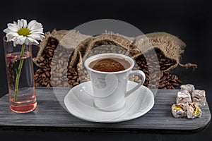 Traditional turkish coffee drink concept. Turkish coffee with glass of water and turkish delights on wooden table