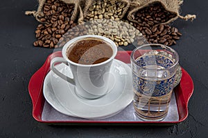 Traditional turkish coffee drink concept. Turkish coffee with glass of water and turkish delights on wooden table