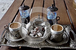 A traditional Turkish coffee set with silver cups on a tray