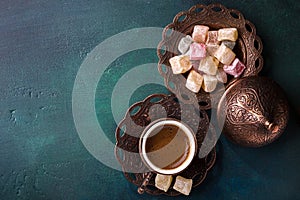 Traditional turkish coffee and turkish delight on dark green wooden background. flat lay