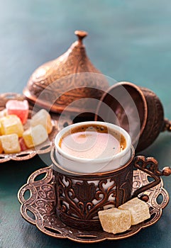 Traditional turkish coffee and turkish delight on dark green wooden background