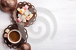Traditional Turkish coffee and Turkish delight on white shabby wooden background. Top view photo