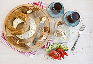 Traditional Turkish,crispy bagel,simit with creamy cheese on wooden plate