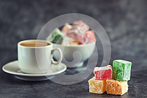 Traditional turkish delight and cup of coffee on grey background