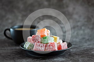 Traditional turkish delight and cup of coffee on grey background