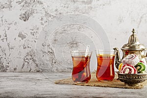 Traditional Turkish delight with Turkish tea on gray background. Ramadan Kareem celebration concept. Fragrant Turkish tea and Turk