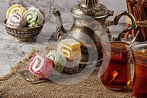 Traditional Turkish delight with Turkish tea on gray background. Ramadan Kareem celebration concept. Fragrant Turkish tea and Turk
