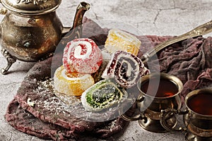 Traditional Turkish delight with Turkish tea on gray background. Ramadan Kareem celebration concept. Fragrant Turkish tea and Turk