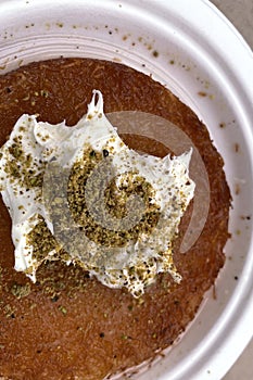 Traditional Turkish Dessert Kunefe with Clotted Cream and Crushed Pistachios. photo