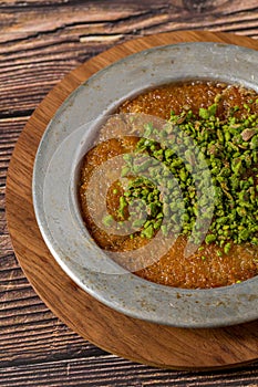 Traditional Turkish dessert pistachio kunefe on wooden table