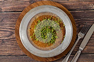 Traditional Turkish dessert pistachio kunefe on wooden table
