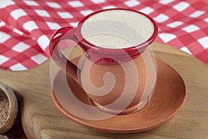 Traditional Turkish Dibek coffee in coffee cup on wooden table. Turkish dibek coffee grinded in a large stone mortar with the