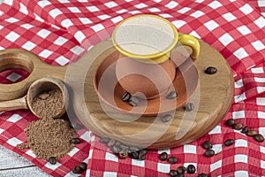 Traditional Turkish Dibek coffee in coffee cup on wooden table. Turkish dibek coffee grinded in a large stone mortar with the