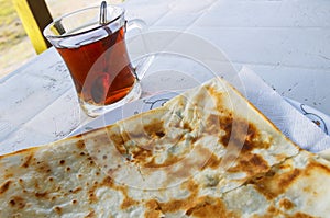 Traditional turkish food flatbread, Gozleme, near cup of turkish tea