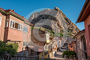Traditional Turkish Ottoman houses in Afyonkarahisar Turkey. Afyon Castle on the rock and Mevlevihane Museum in front of it
