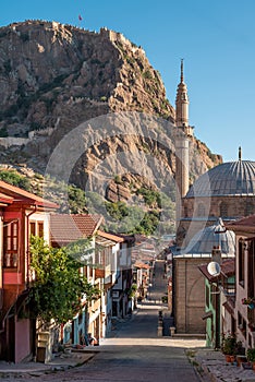 Traditional Turkish Ottoman houses in Afyonkarahisar Turkey. Afyon Castle on the rock and Mevlevihane Museum in front of it