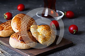 Traditional Turkish pastries pogaca with cheese on cutting board