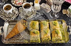 Traditional Turkish Pastry Pistachio Baklava,on tray with coffee and delights.