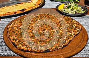 Traditional Turkish pizza, called Lahmacun, being prepared with meat, onion and parsley photo