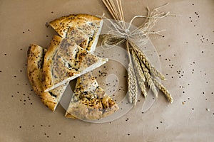 Traditional Turkish Ramadan Bread sliced on kraft paper with a bouquet of natural wheat ears