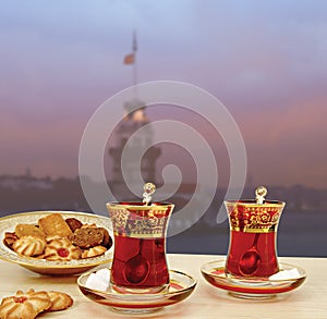Traditional Turkish tea set of 2 tea glasses with Maiden Tower Istanbul silhouette background. photo