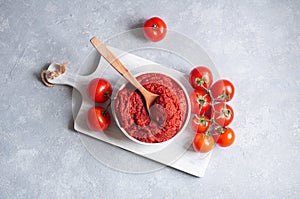 Traditional turkish tomato paste in bowl with fresh tomatoes on rustic table