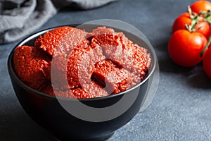 Traditional turkish tomato paste in bowl with fresh tomatoes on rustic table