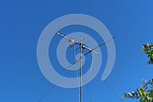 A traditional TV antenna on a high roof