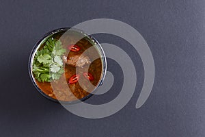 Traditional Ukrainian beetroot soup - borscht or borshch with meat and fresh parsley over black background. Copy space.