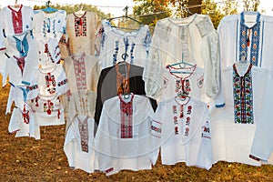 Traditional ukrainian dresses on flea market. Different Ukrainian vintage clothes - traditional embroidered shirts