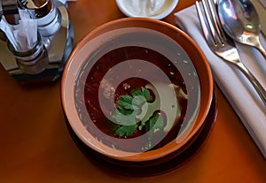 Traditional Ukrainian red borscht in meat broth with greens