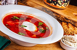 Traditional Ukrainian Russian borscht or beetroot red soup with sour cream in white plate