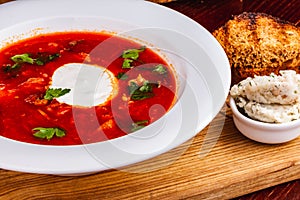 Traditional Ukrainian Russian borscht or beetroot red soup with sour cream in white plate