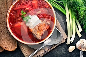 Traditional Ukrainian russian borscht. Plate of red beet root soup borsch on black rustic table. Beetroot soup