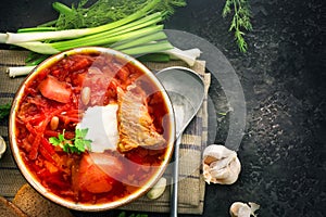 Traditional Ukrainian russian borscht. Plate of red beet root soup borsch on black rustic table. Beetroot soup