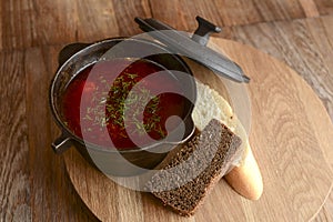 Traditional Ukrainian Russian soup, Borscht. Beetroot soup in bowl on wooden board and rustic wooden background