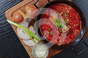 Traditional Ukrainian Russian vegetable borscht. Ukrainian beetroot soup in a bowl with meet, greenery and garlic bread