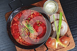 Traditional Ukrainian Russian vegetable borscht. Ukrainian beetroot soup in a bowl with meet, greenery and garlic bread