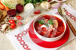 Traditional Ukranian soup borsch on a white napkin embroidered in Ukrainian style.