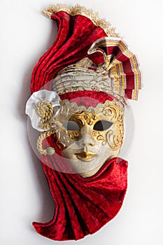 Traditional Venetian mask with red and gold decor isolated on white background.