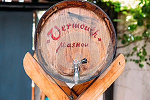 Traditional vermouth wooden barrel in outdoors spanish house during sunny summer day photo