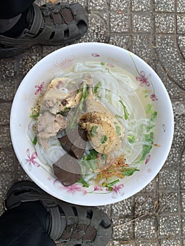 A traditional Vietnamese street food name is Banh Canh, noodle soup of recipe: chicken drumstick, pepper and onion