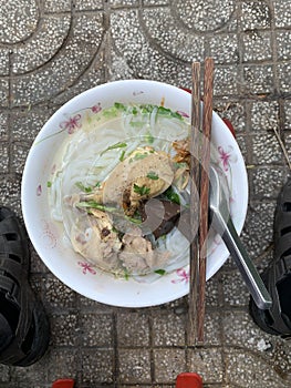 A traditional Vietnamese street food name is Banh Canh, noodle soup of recipe: chicken drumstick, pepper and onion