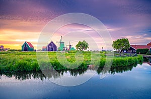 Traditional village with dutch windmills and river at sunset, Holland, Netherlands.