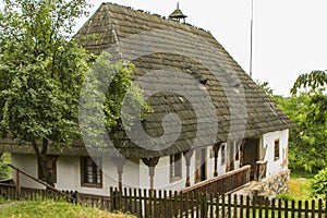 Traditional village historical building of Western Ukraine, where the roof is covered with wooden tiles. Skansen Uzhhorod. Ukraine