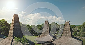 Traditional village houses roofs closeup at tropic green landscape. Ornately homes rooftops