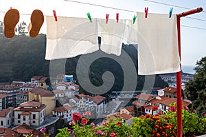 Traditional way to wash and dry clothes in Spain. White clothes hanging outdoors. Beautiful town, colorful houses built on the