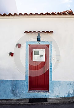 Traditional white and blue stone house with tiled roof and various decoration the entrance to the house